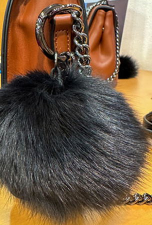 Particolare ciondolo Pon Pon di una Pashbag con tracollina catena